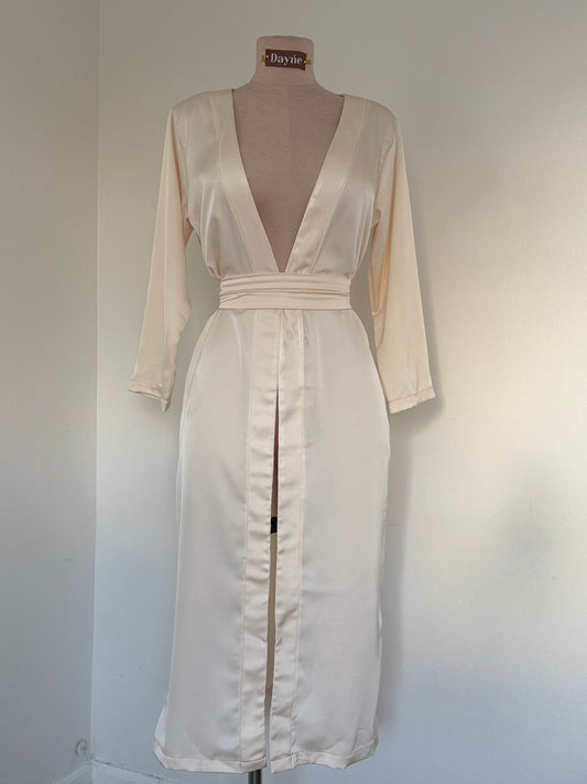 White satin cardigan on a mannequin against a plain background
